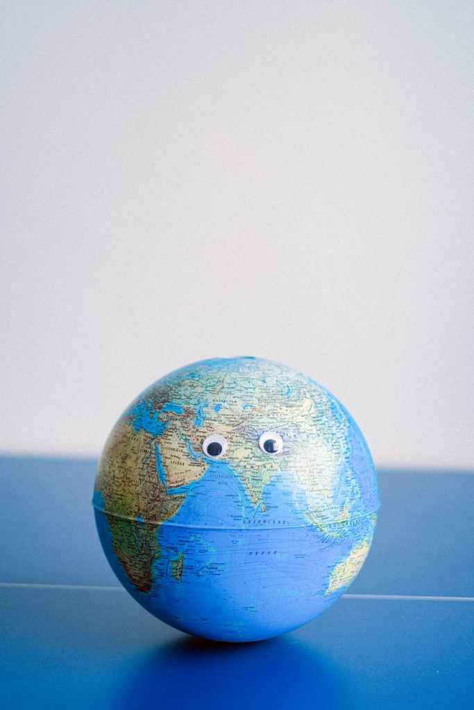 sphere shaped miniature of earth with googly eyes, world economies will depend on the relationship between china and the US